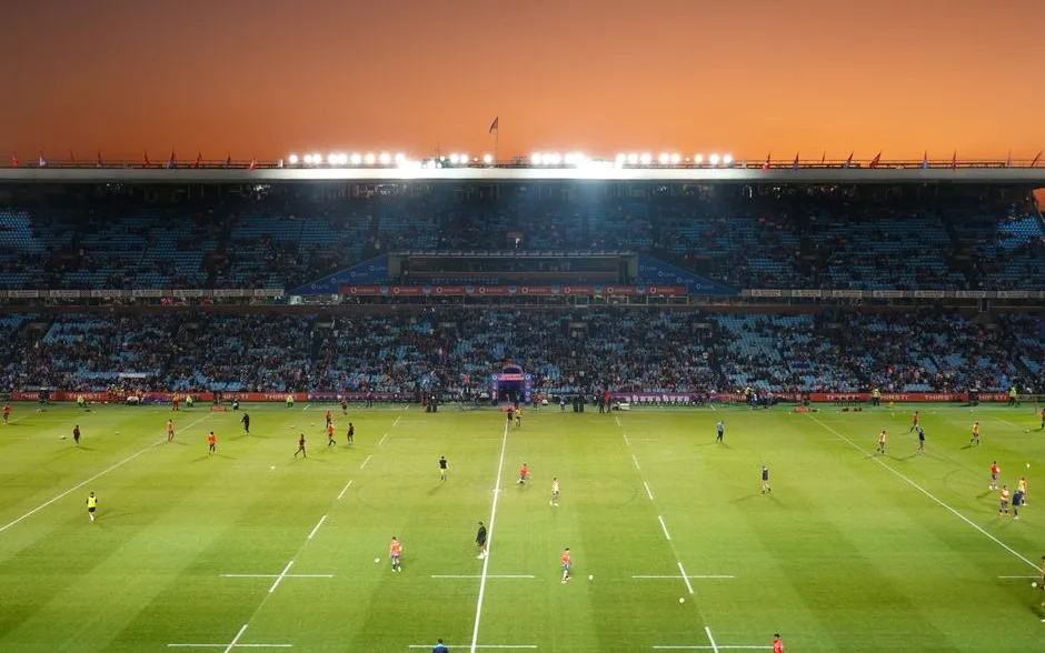 Match de rugby dans un grand stade au coucher du soleil